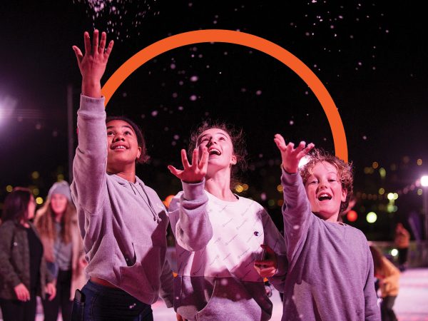 bondi-festival-ice-rink-three-children-throwing-snow-into-the-air-at-night-on-ice-rink-bondi-festival-letter-o