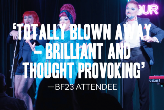 A mid-performance image of three performers in drag, with text over the top that says "TOTALLY BLOWN AWAY - BRILLIANT AND THOUGHT PROVOKING" - BF23 ATTENDEE